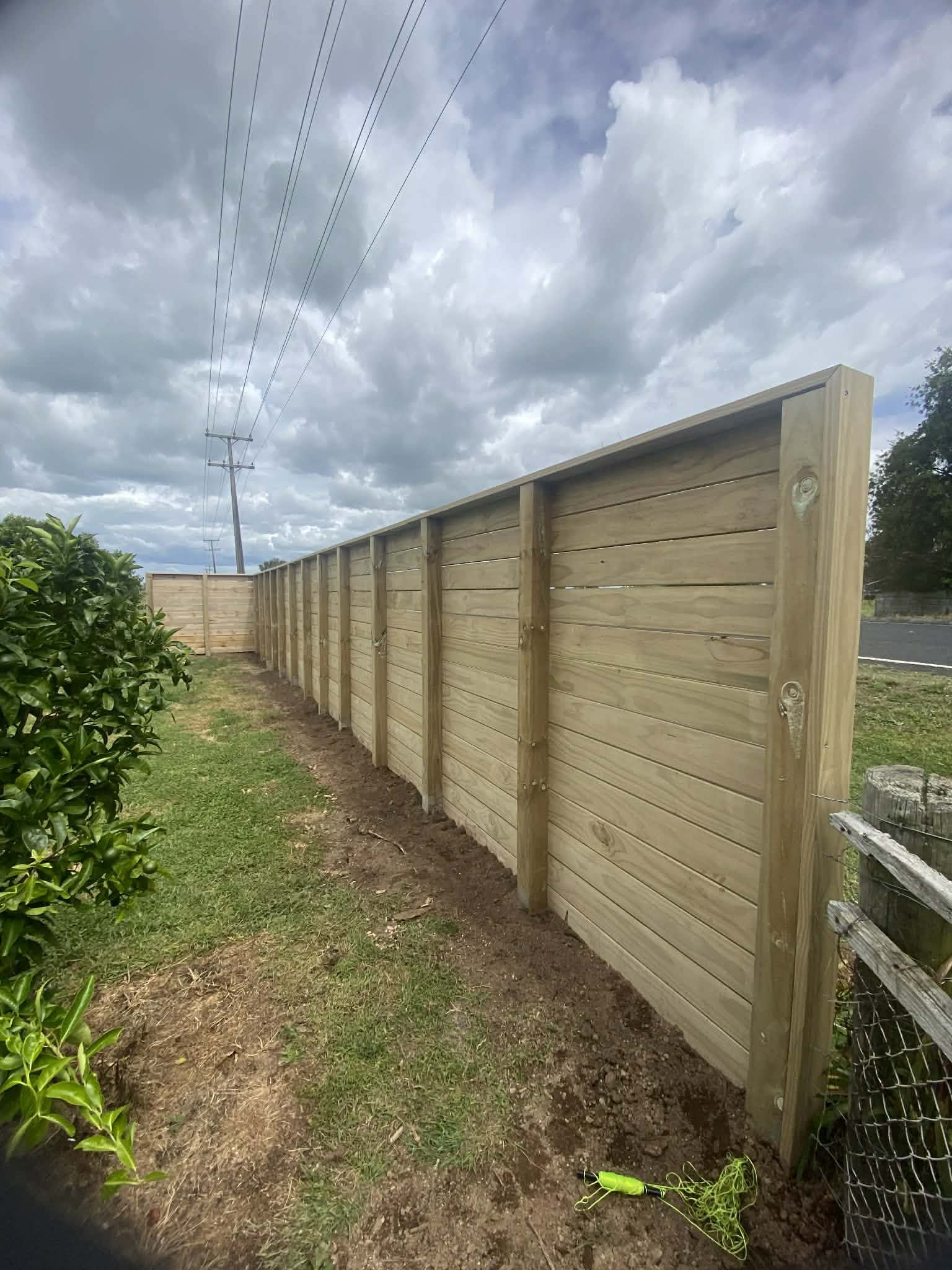 Long horizontal timber boundary fence with post caps — Element Landscaping Waikato